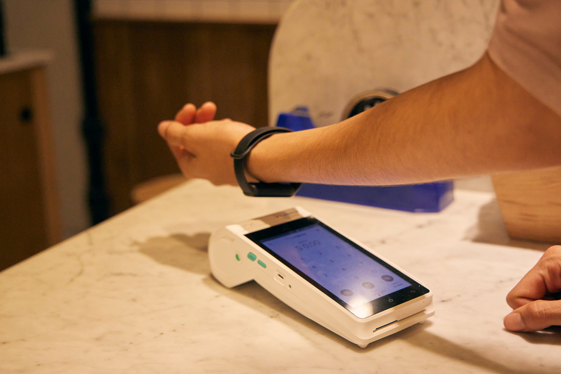 웨어러블 기기를 NFC 결제 단말기에 태그하는 모습
